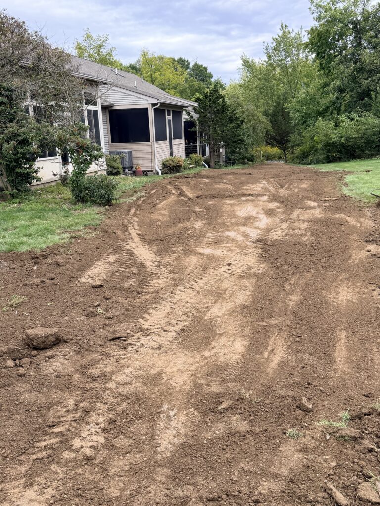 Freshly graded topsoil spread by Blue Mountain LandWorks behind a home